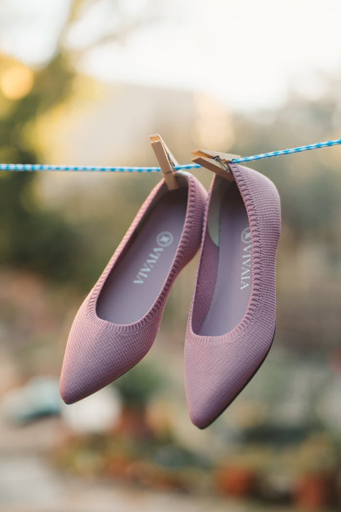 Purple shoes hanging on a clothesline outdoors, a blend of fashion and creativity.